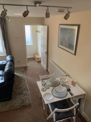 a living room with a table with plates on it at 1 bedroom townhouse in North Yorkshire in Harrogate