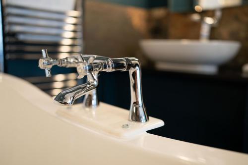 a bathroom sink with a chrome water faucet at No11 Boutique Hotel & Brasserie in Edinburgh