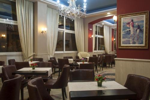 un restaurante con mesas y sillas y una lámpara de araña en Hotel Marianna en Dráma