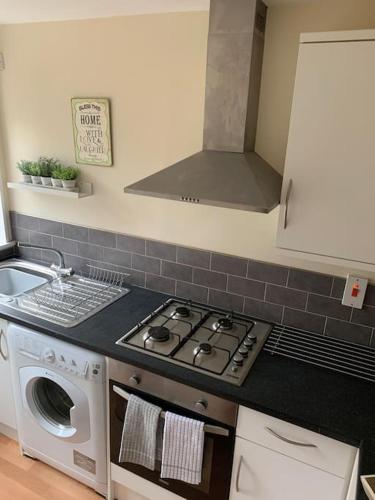 a kitchen with a stove top oven next to a sink at 1 bedroom townhouse in North Yorkshire in Harrogate