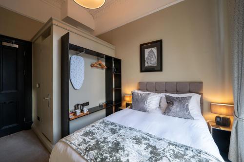 a bedroom with a bed with white sheets and pillows at No11 Boutique Hotel & Brasserie in Edinburgh