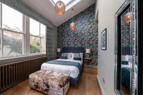 a bedroom with a bed and a chair and windows at No11 Boutique Hotel & Brasserie in Edinburgh