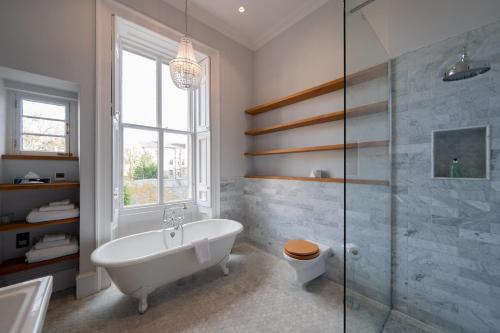 a bathroom with a tub and a glass shower at No11 Boutique Hotel & Brasserie in Edinburgh