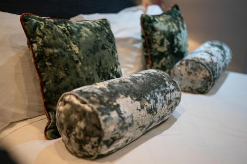 a group of pillows sitting on top of a bed at No11 Boutique Hotel & Brasserie in Edinburgh