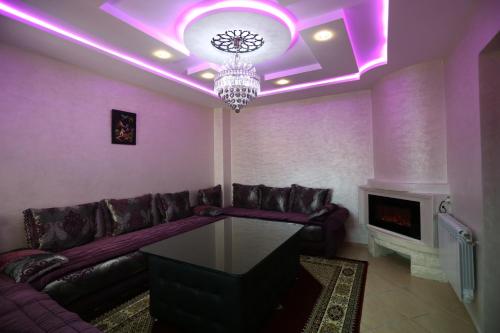 a purple living room with a couch and a chandelier at APPARTEMENT AMIRA iFRANE in Ifrane
