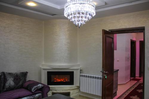a living room with a chandelier and a fireplace at APPARTEMENT AMIRA iFRANE in Ifrane
