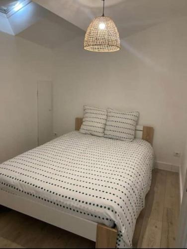 Ce lit se trouve dans un dortoir doté d'une lampe suspendue au-dessus. dans l'établissement Superbe appartement au château d’Aubenas, à Aubenas