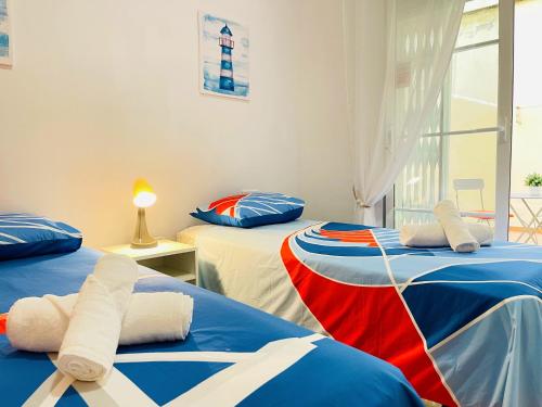 Zimmer mit 2 Betten in Blau und Rot in der Unterkunft ARENAL GOLF HOME in Benalmádena