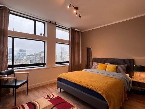 a bedroom with a bed and two large windows at City View 2 Bedrooms Flat in Manchester