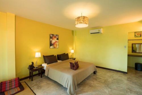 a bedroom with a large bed and yellow walls at River CoCo @ Amphawa in Samut Songkhram