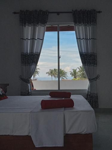 a bedroom with a bed with a view of the ocean at Indika's Apartment in Hikkaduwa