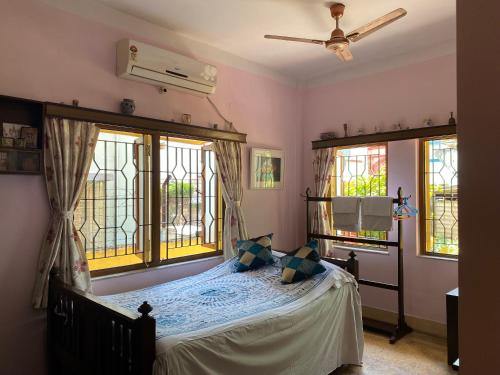 a bedroom with a bed and two windows at Far From The Madding Crowd in Taliganja