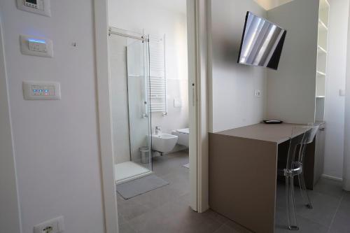 TV y baño con lavabo y aseo. en Piano Alto Home, en Pescara