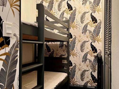 Ce lit superposé se trouve dans un dortoir revêtu de papier peint. dans l'établissement Studio pieds des pistes avec piscine extérieure - FR-1-505-51, à Notre-Dame-de-Bellecombe