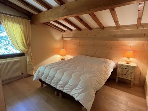1 dormitorio con 1 cama grande y 2 lámparas. en Appartement Megève, 2 pièces, 4 personnes - FR-1-597-169, en Megève