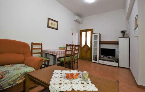 a living room with a couch and a table at Apartment Lopar, Primorje-Gorski Kotar 2 in Lopar