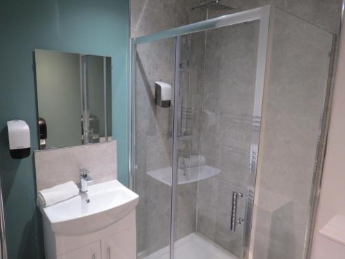 uma casa de banho com um chuveiro, um lavatório e um WC. em Eazy apartments em Newcastle upon Tyne