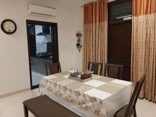 uma sala de jantar com mesa e cadeiras e um relógio em Colonel's Abbey em Jaipur