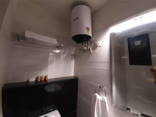 uma casa de banho com um WC e um chuveiro com luz em Colonel's Abbey em Jaipur