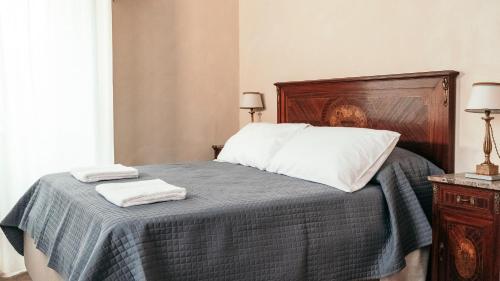 a bedroom with a bed with two towels on it at Puleera Boutique Hotel in San Leonardello