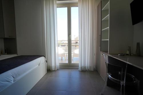 um quarto com uma cama e uma grande janela em Piano Alto Home em Pescara