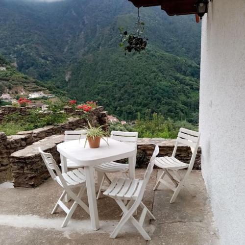 a white table and chairs with a view of a mountain at La Finestra Verde in Montignoso