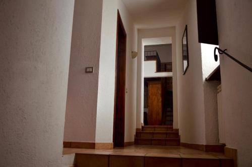 a hallway with stairs and a wooden door at Residenza San Jacopo in Spello