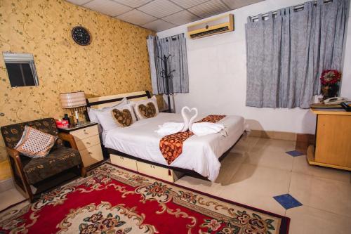 a bedroom with a bed and a chair in it at Babylon Hotel & Serviced Apartment in Dhaka