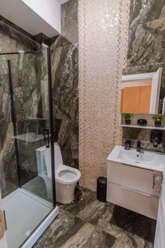 a bathroom with a shower and a toilet and a sink at Penthouse Luxury Falticeni in Fălticeni