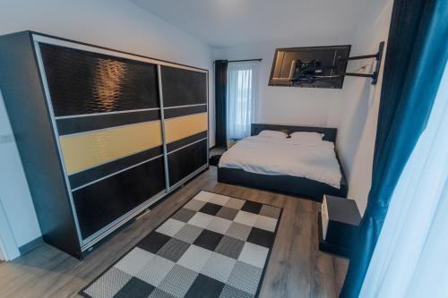 a small bedroom with a bed and a dresser at Penthouse Luxury Falticeni in Fălticeni