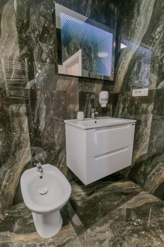a bathroom with a sink and a white toilet at Penthouse Luxury Falticeni in Fălticeni