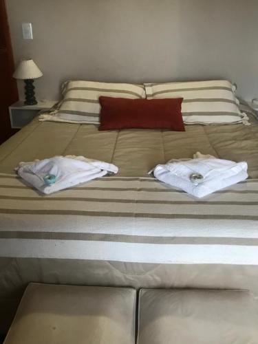 Una cama con dos toallas encima. en EL PARAISO DEL DESCANSO en Sierra de los Padres