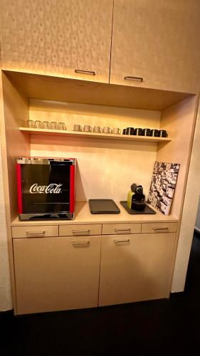 a kitchen with a cocacola appliance on a shelf at smart&beautiful HOSTEL in Nordkirchen