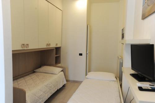a small room with two beds and a tv at Le Gemme 1 in Empoli