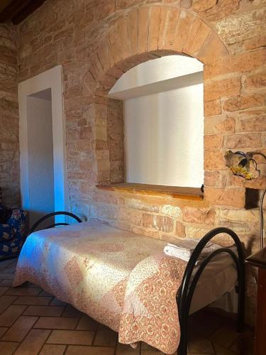 a bedroom with a bed in a stone wall at Residenza San Jacopo in Spello