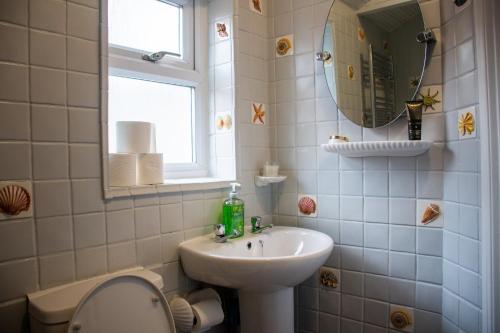 a bathroom with a sink and a toilet and a mirror at Royale Green View House- free parking, Wifi, Perfect for Contractors and Holiday in Northampton