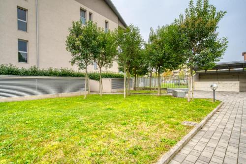 a yard with trees in front of a building at CaseOspitali - Casa Francesca, modernissimo trilocale per 6 in Pioltello