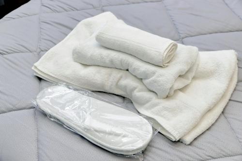 un mucchio di asciugamani bianchi su un letto di Druso Dream Apartment Colosseo a Roma