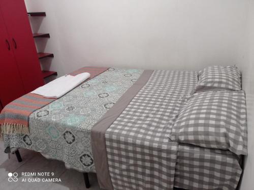 a bed with a quilt on it in a room at FT Casa Flores Ayacucho 100 in Ayacucho