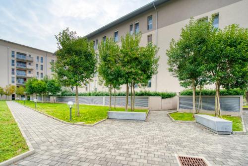 a courtyard with trees in front of a building at CaseOspitali - Casa Francesca, modernissimo trilocale per 6 in Pioltello