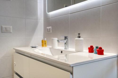 uma casa de banho branca com um lavatório e um espelho em CaseOspitali - Casa Francesca modernissimo trilo accessibile em Pioltello