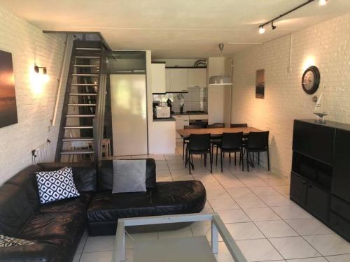 a living room with a couch and a dining room at Bruinisse-Zeeland-Holland in Bruinisse
