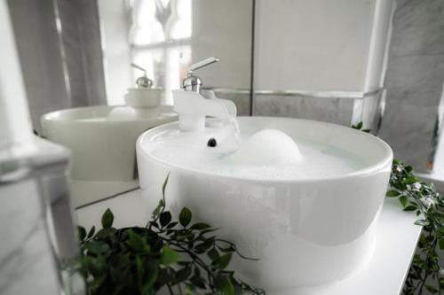 a white sink in a bathroom with a mirror at Milverton Hotel in Manchester