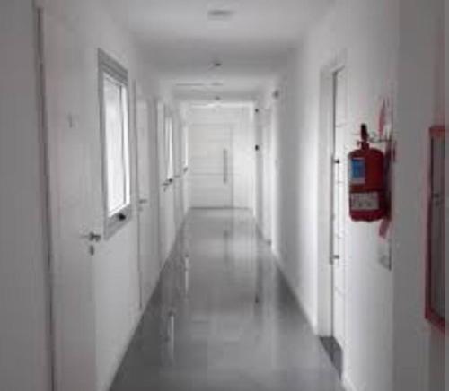 an empty hallway with a fire extinguisher in a building at Monoambiente frente al río en Ramallo in Ramallo