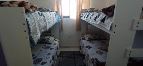 Cette petite chambre comprend 2 lits superposés et un miroir. dans l'établissement Condominio Recanto das palmeiras, à Campos dos Goytacazes