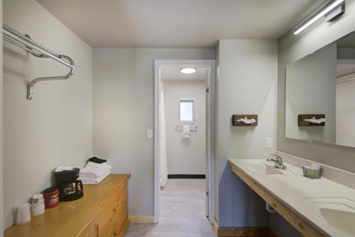 uma casa de banho com um lavatório e um espelho grande em Lantern Inn em Hill City