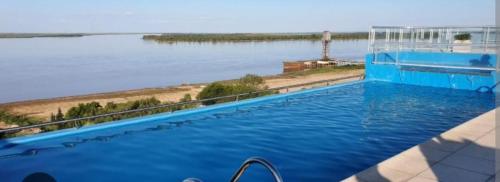 a swimming pool with a view of the water at Monoambiente frente al río en Ramallo in Ramallo