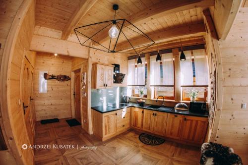 eine Küche in einem Blockhaus mit einem Waschbecken in der Unterkunft MALCYKÓWKA - domki góralskie in Ząb