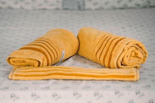 um par de toalhas sentadas em cima de uma cama em Chalé aconchegante, pertinho da cidade e conectada a natureza em Brasília