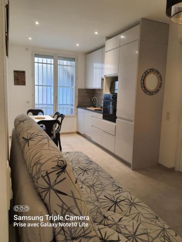 un salon avec un canapé et une cuisine dans l'établissement Les Violettes 3 pièces centre ville Antibes, à Antibes